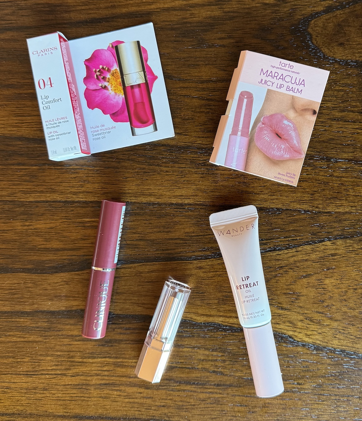 Clarins Lip Comfort Oil Pitaya, Clinique Almost Lipstick Black Honey, Lancome Lip Idole Butterglow Keep It Glowy, Tarte Maracuja Juicy Lip Balm Rose, and Wander Beauty Lip Retreat Oil Oasis Glow